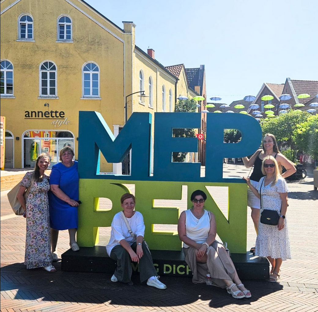Besucher aus Lettland vor dem MEPPEN Logo in der Stadt Meppen